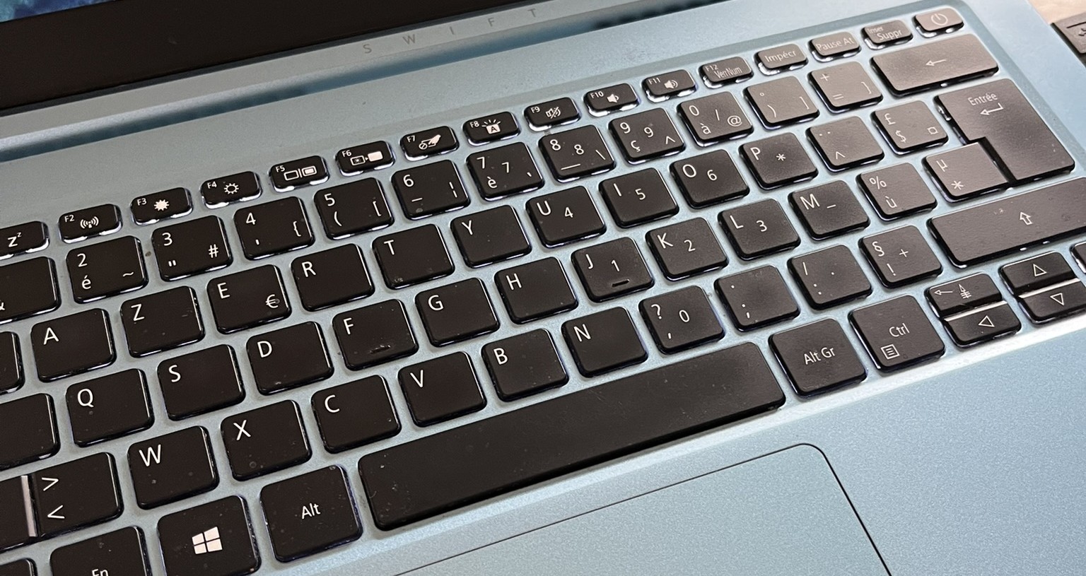 Clavier d'un ordinateur portable turquoise vu de côté