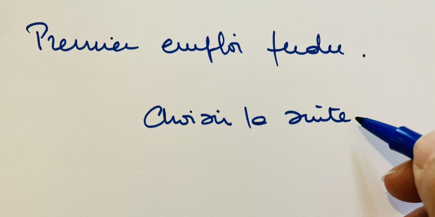 Main écrivant « Premier emploi perdu, choisir la suite » au feutre bleu